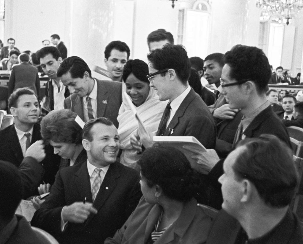 black and white photograph of people discussing in a room